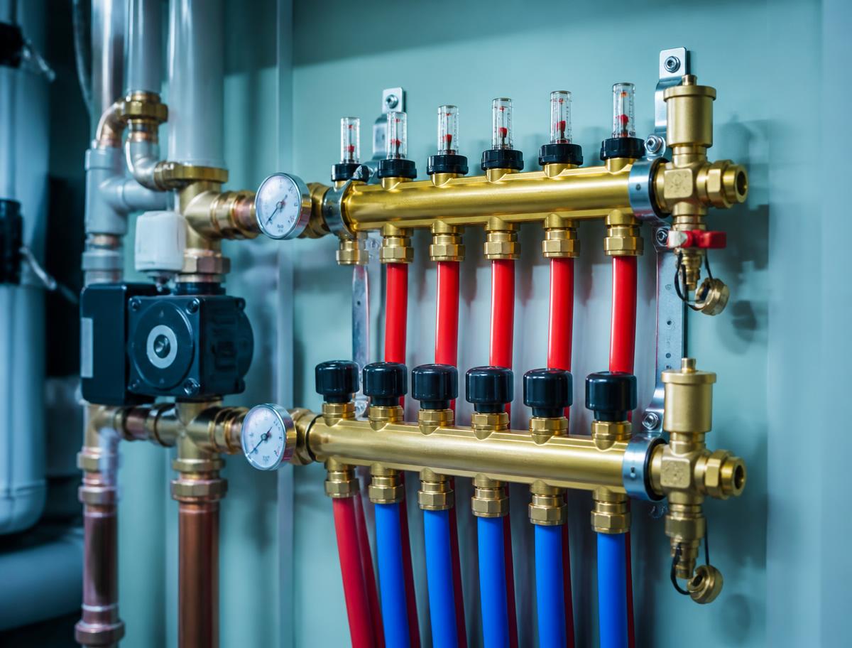 Hydronic manifold with brass fittings and red and blue PEX lines